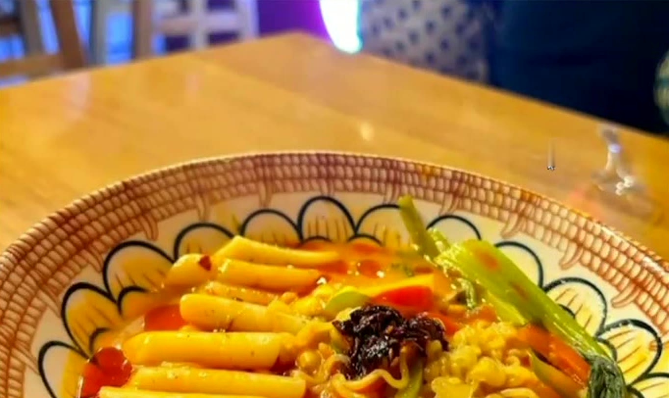A bowl of rabokki at Toku's: ramen noodles and rice cakes in a red, sweet-spicy sauce