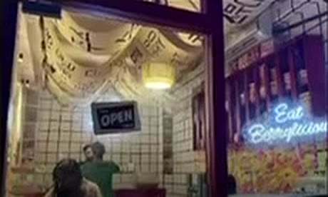 Inside the room: tiled walls, an Open sign, neon and fabric draped from the ceiling